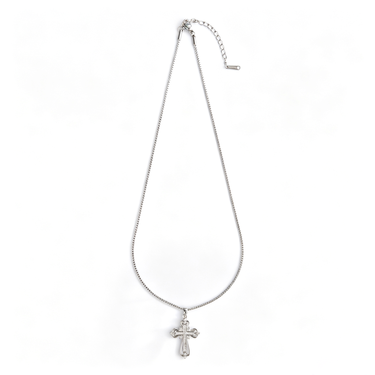 Full view of a silver-tone filigree cross pendant necklace laid flat on a white background.
