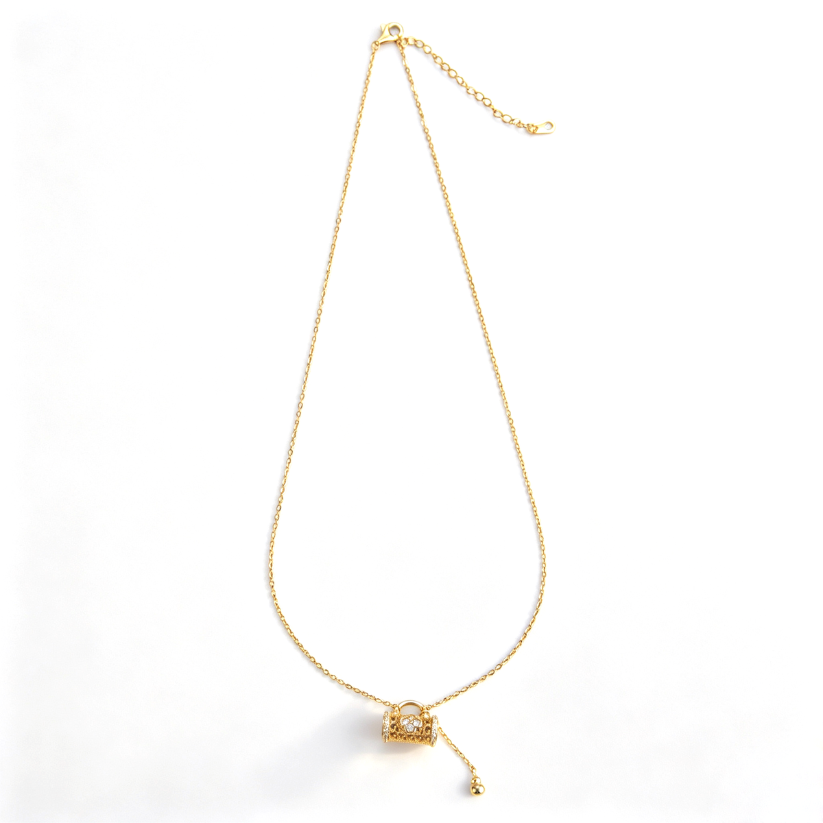 Full product shot of a gold filigree floral lock tassel pendant necklace displayed on a white background.