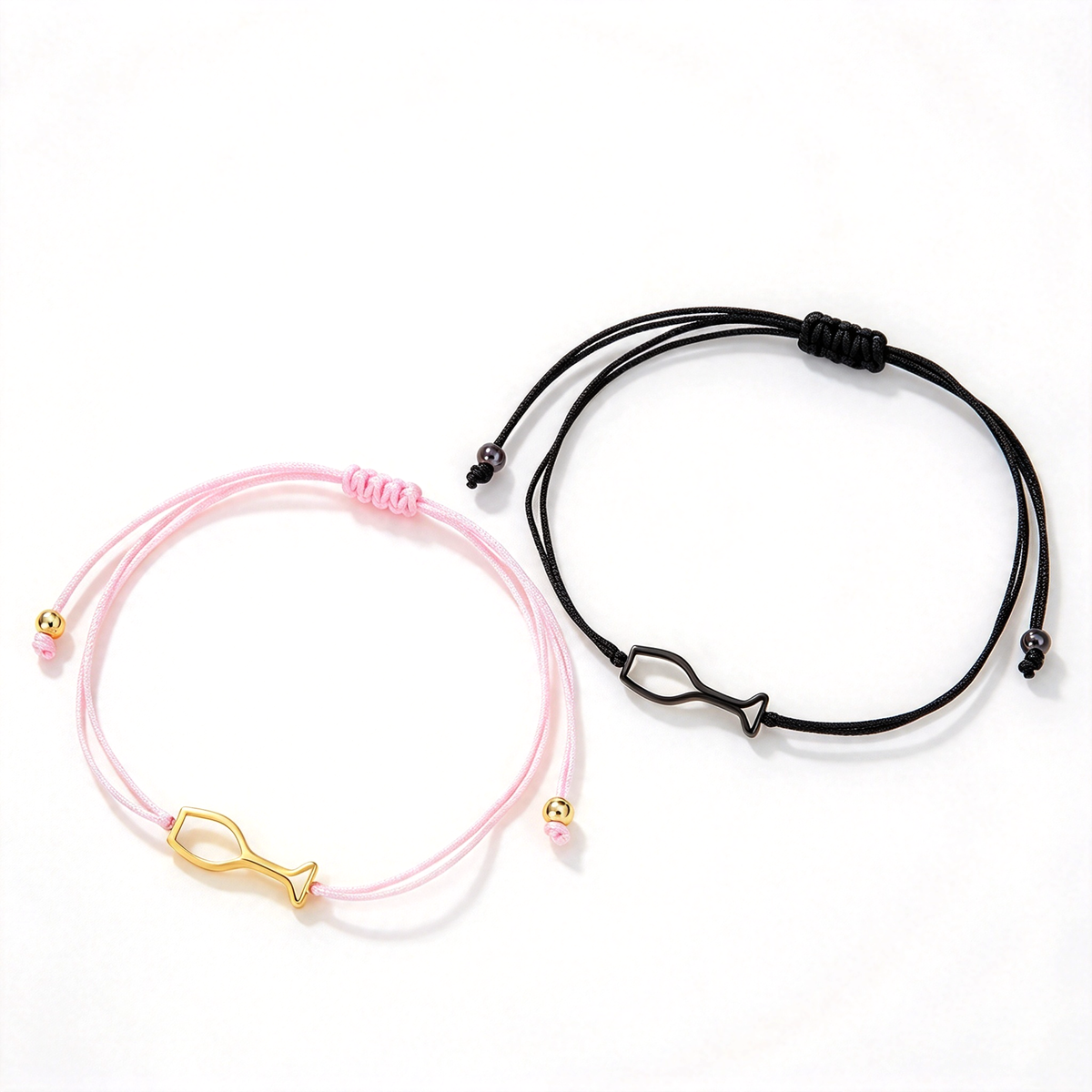 Fish charm adjustable cord bracelets in pink and black displayed together on a white background.