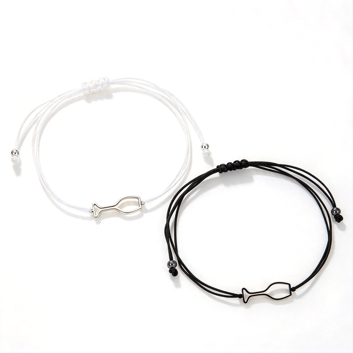 White and black cord bracelets with matching fish-shaped outline charms shown side by side.