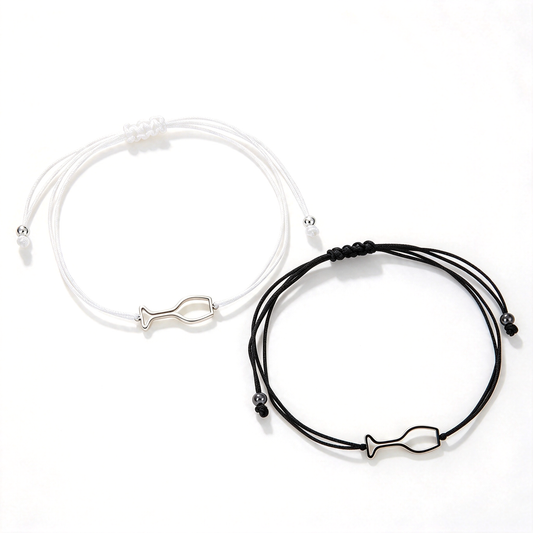 White and black cord bracelets with matching fish-shaped outline charms shown side by side.