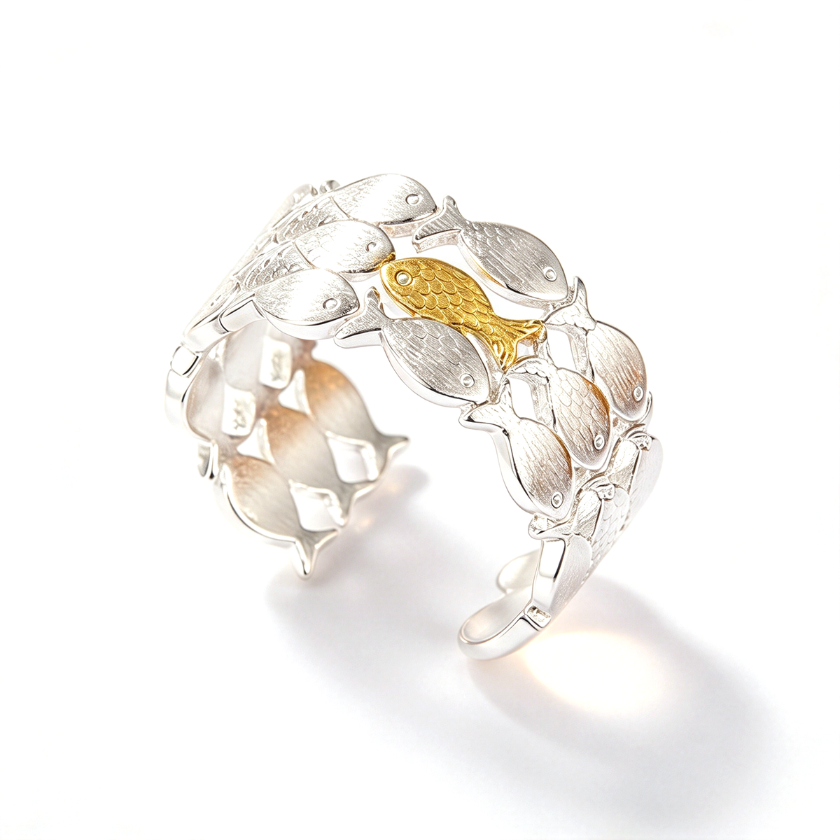 Angled view of a fish school ring showing its curved open band and layered fish-shaped design