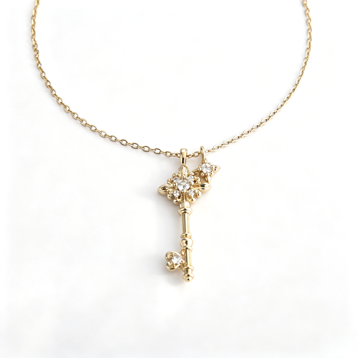 Front view of a gold-plated fleur-de-lis key pendant with sparkling cz accents on a cable chain.