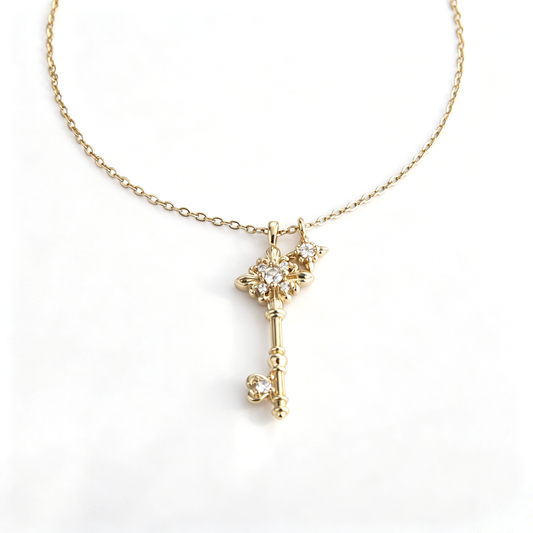Front view of a gold-plated fleur-de-lis key pendant with sparkling cz accents on a cable chain.