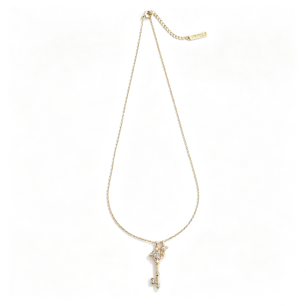 Full view of a gold fleur-de-lis key pendant necklace laid flat on a white background.