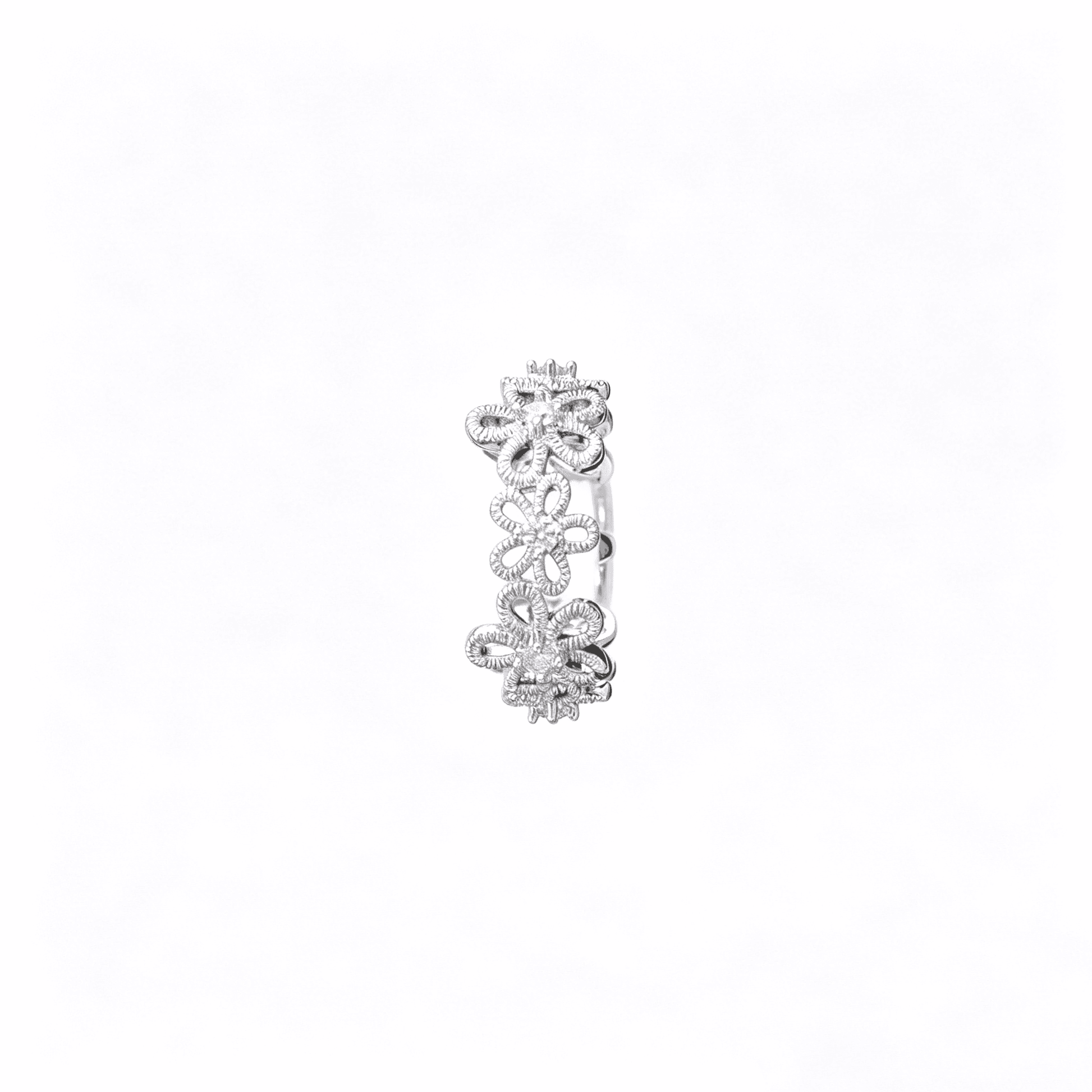 Macro view of the silver plated floral lace wedding band alternative showcasing the intricate textured petals and stone centers.