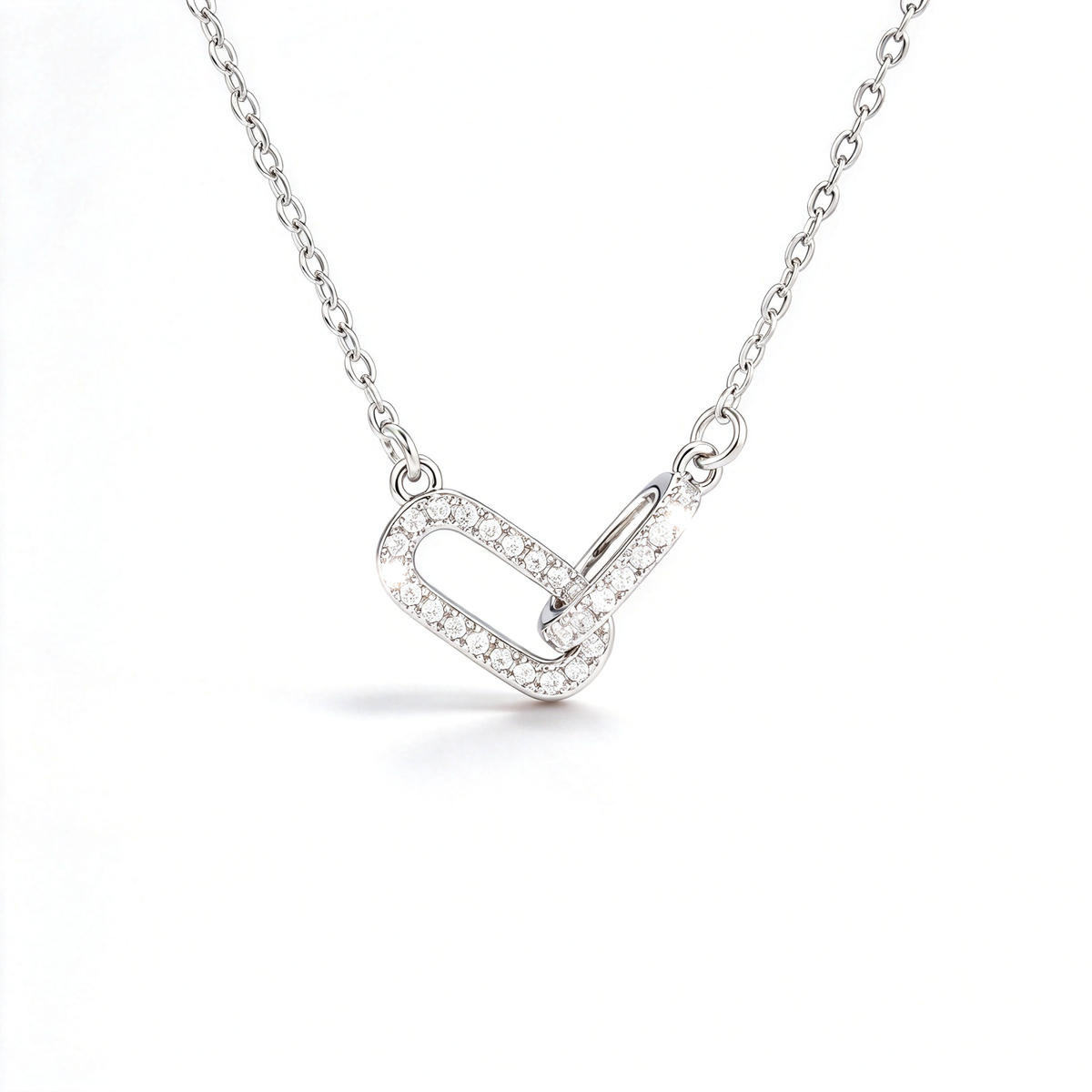 Silver-tone geometric link pendant necklace with interlocking shapes and sparkling pavé-style details.