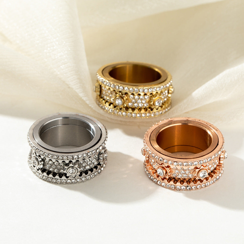 Gold-tone, rose-gold-tone, and silver-tone rings arranged together on a light fabric surface.