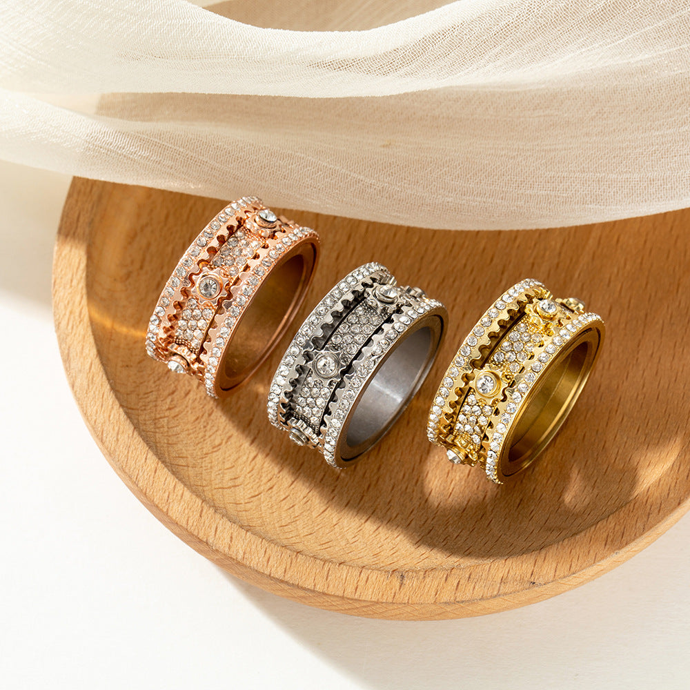 Three rings in different color options displayed together on a soft beige jewelry cushion.