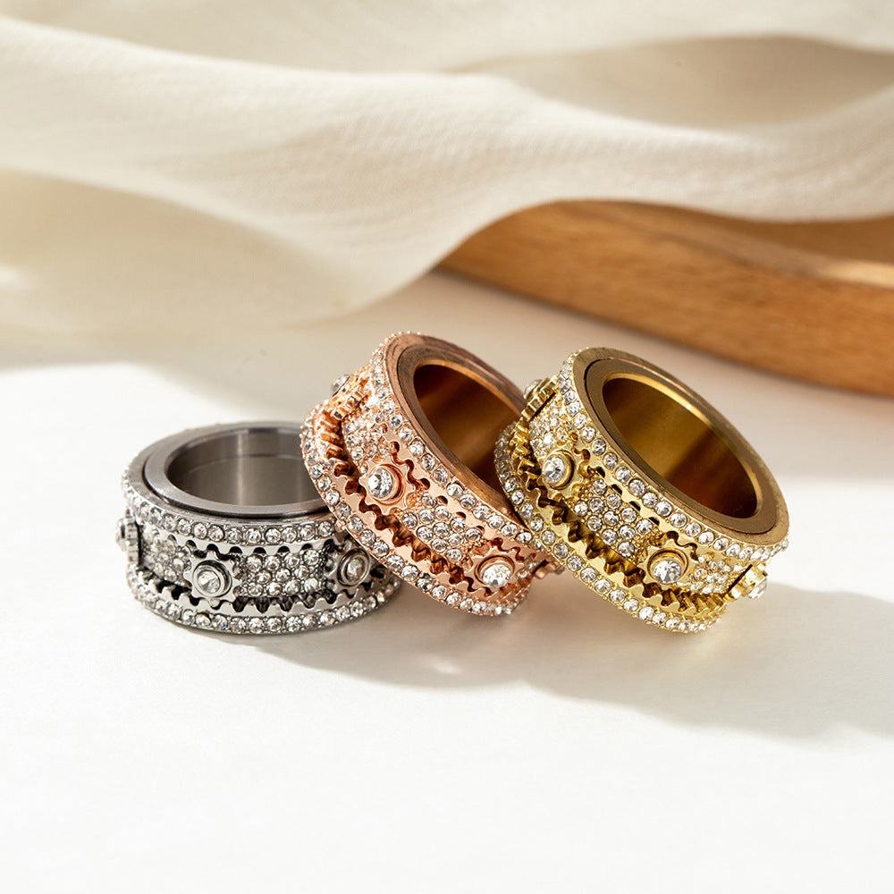 Three decorative rings arranged side by side on a neutral display surface, showing their layered band designs.