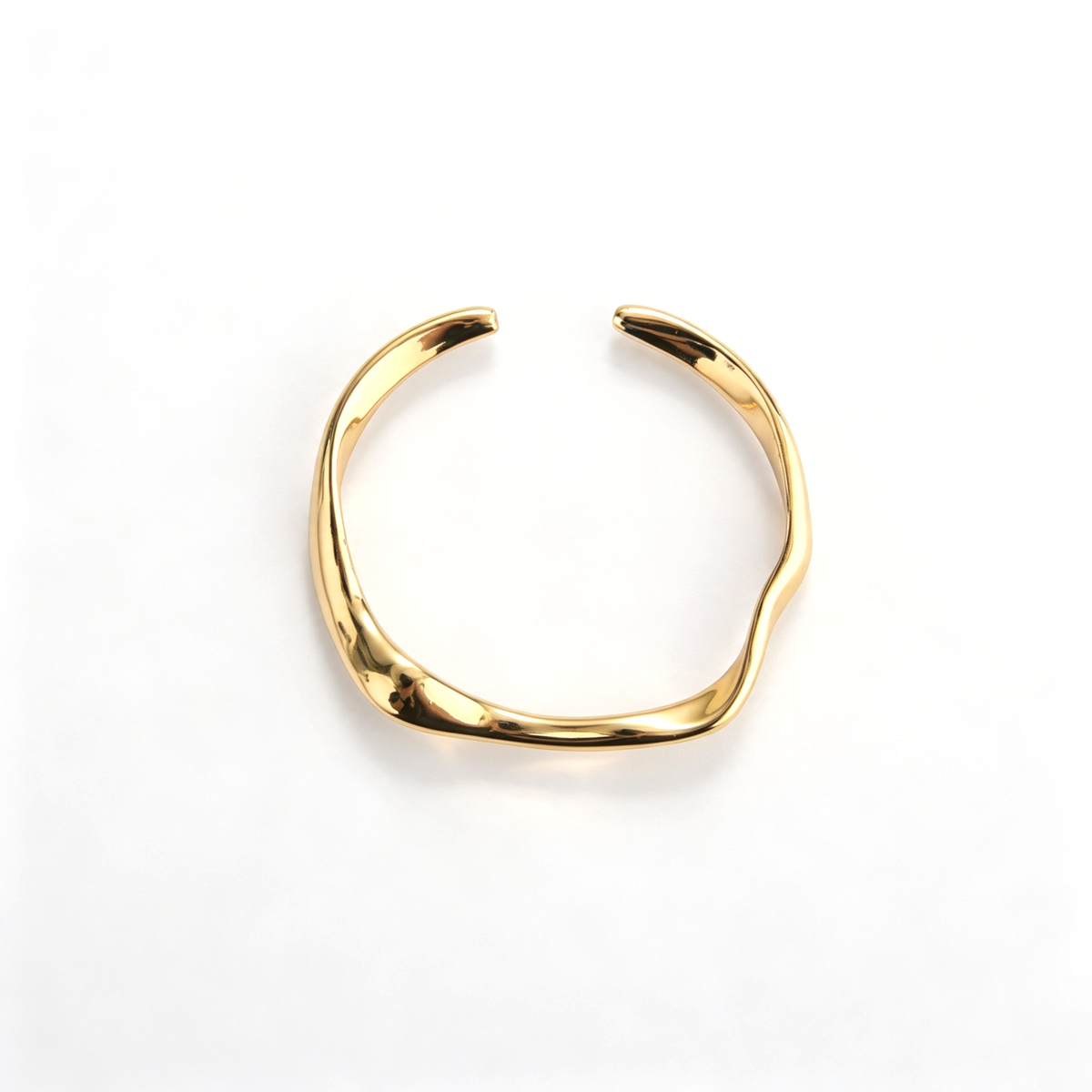 Gold cuff bracelet with a sculptural open silhouette and curved design
