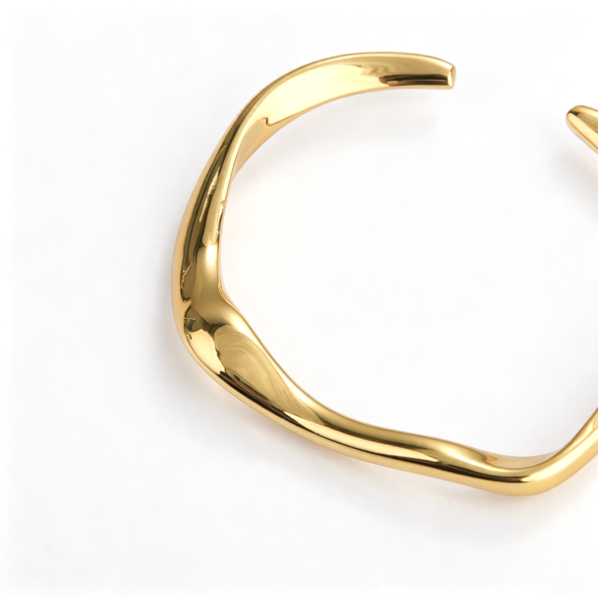 Close-up view of the curved sculptural detail on an open cuff bracelet
