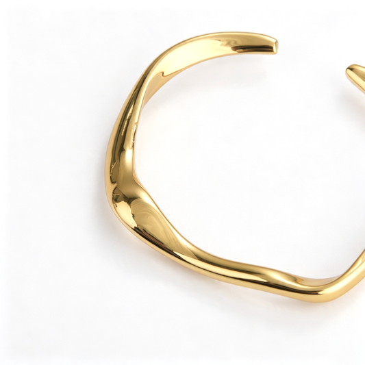 Close-up view of the curved sculptural detail on an open cuff bracelet