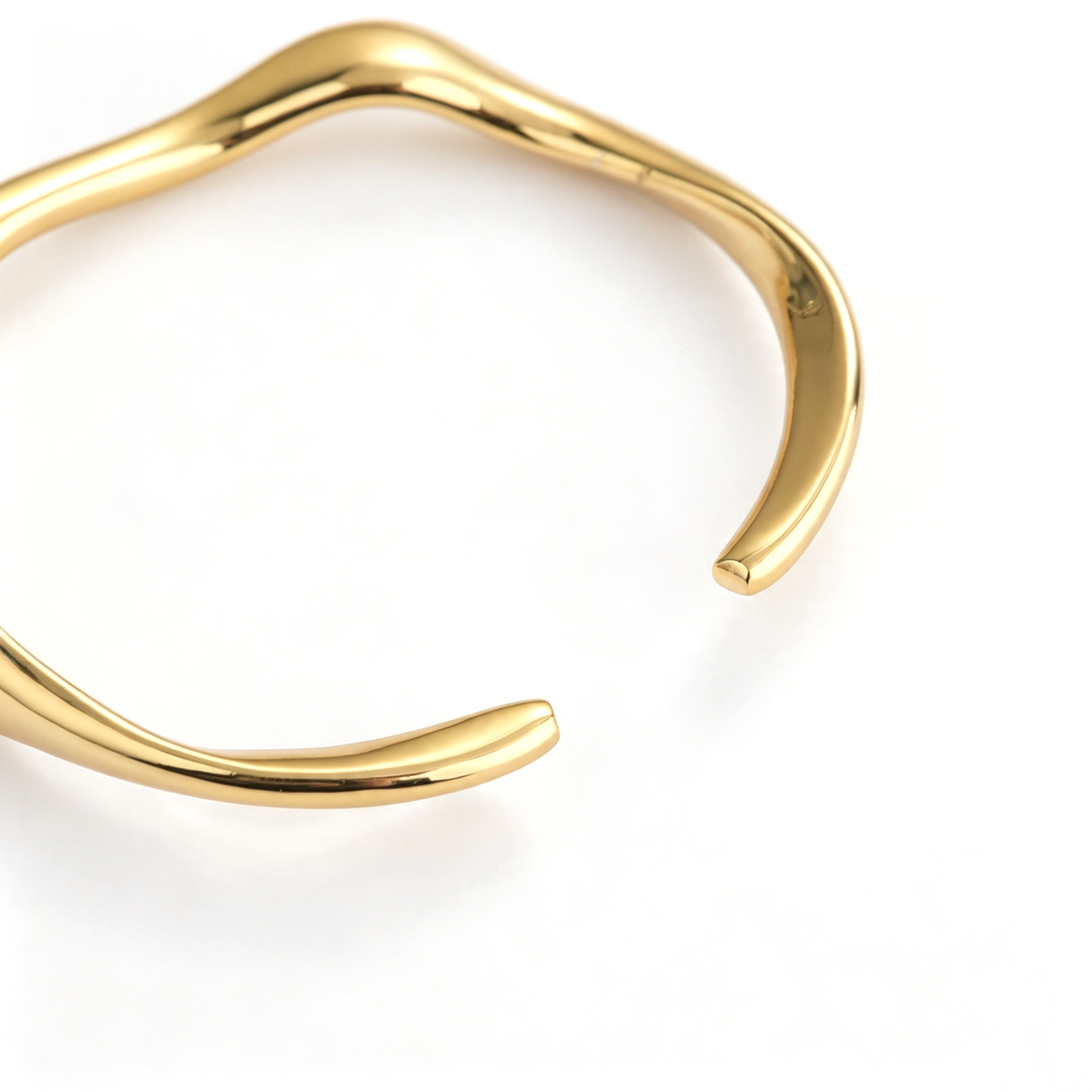 Top view of a sculptural open cuff bracelet showing its curved silhouette