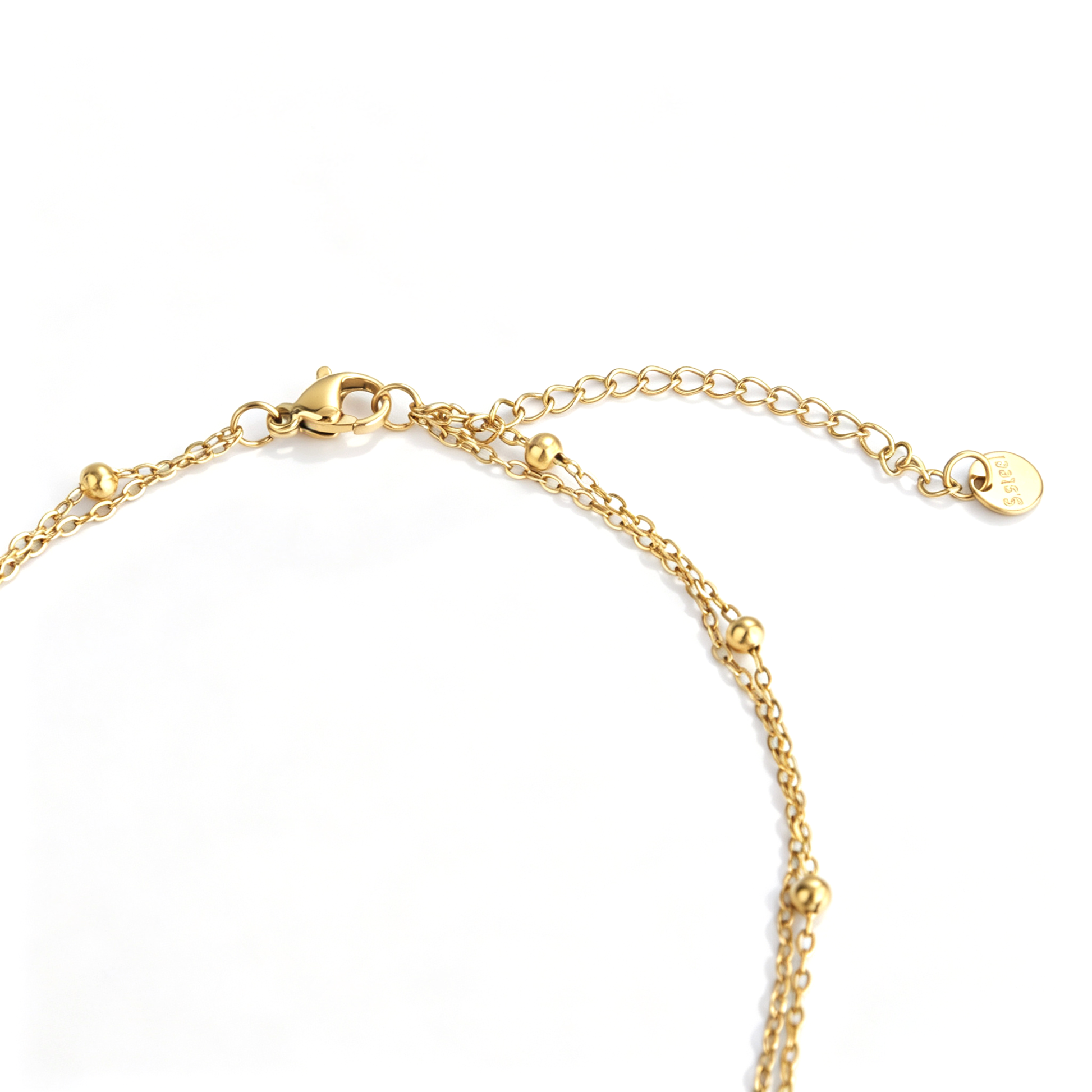 Gold-tone layered necklace lobster clasp, double-chain connectors, and extender on white