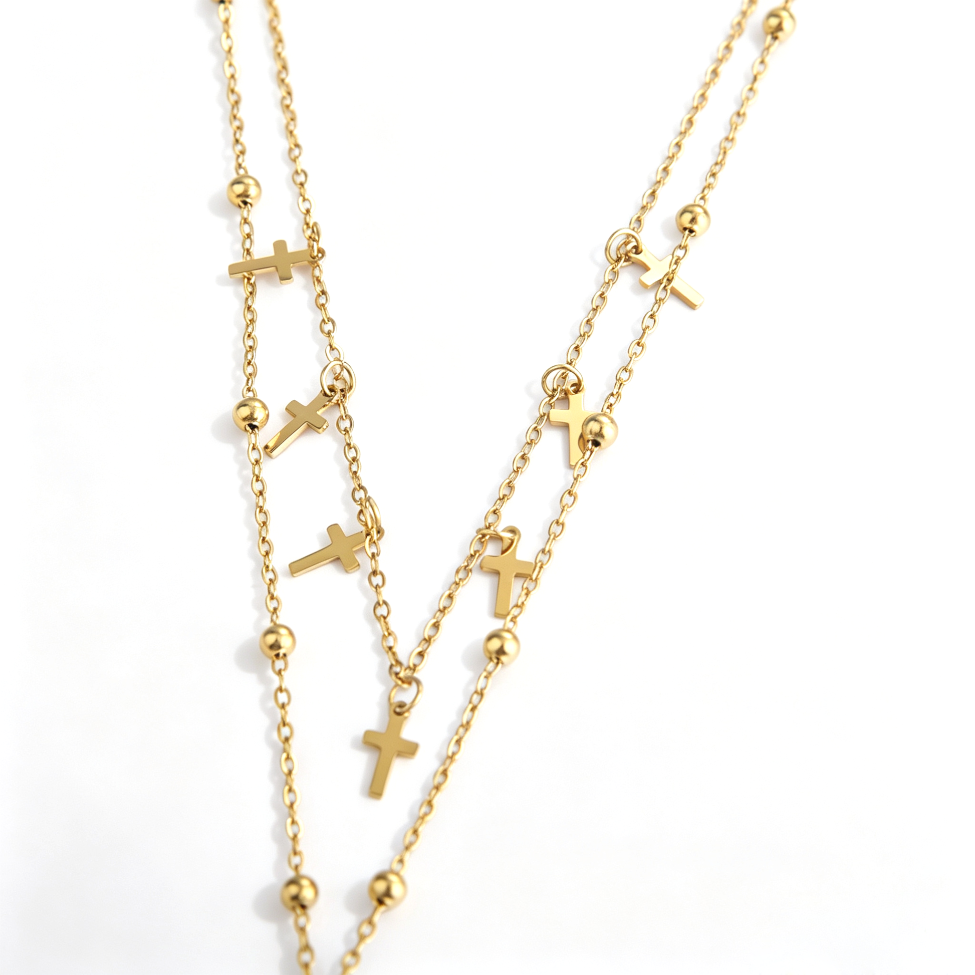 Small gold-tone cross charms and polished beads along the layered chains
