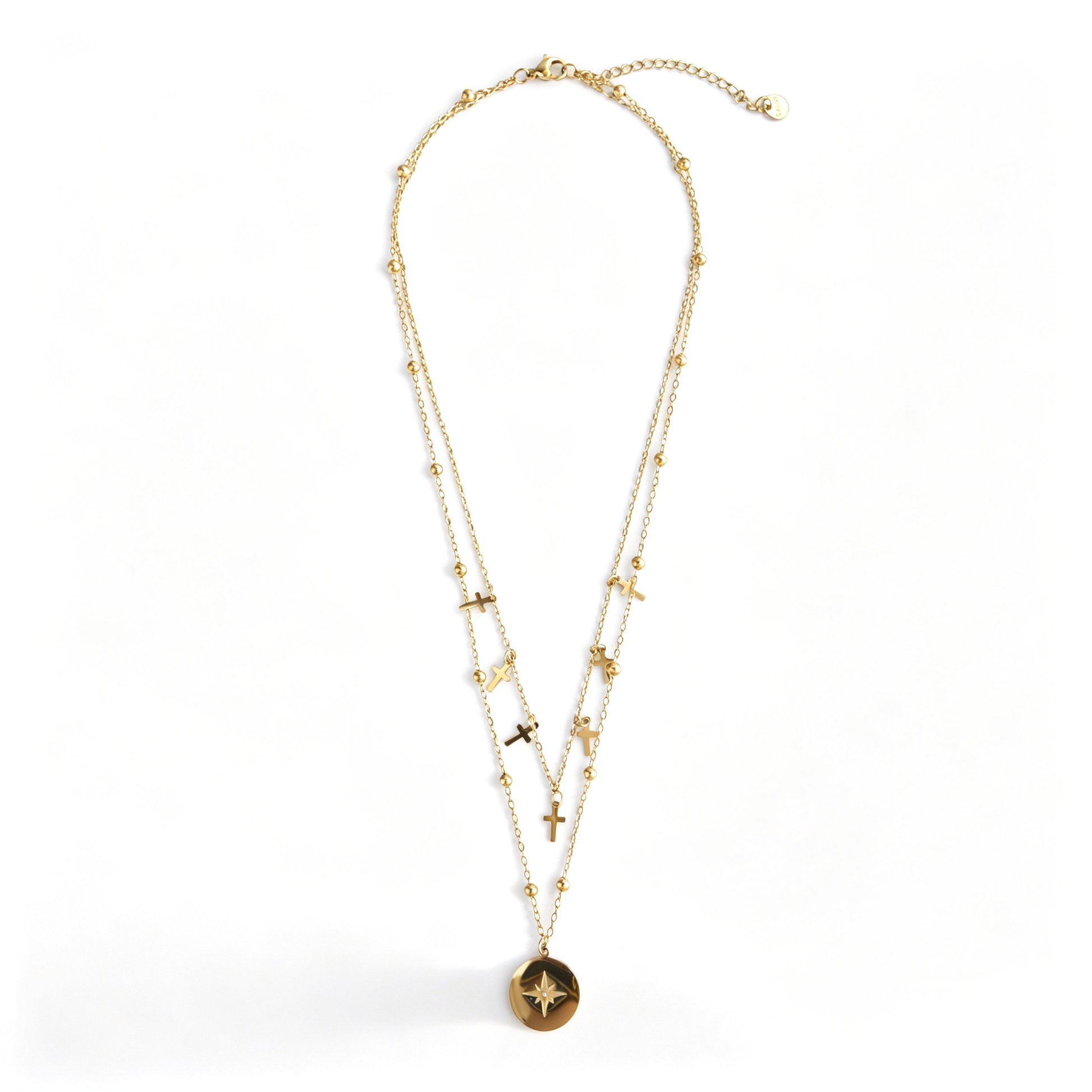 Full gold-tone layered cross necklace with starburst coin on white