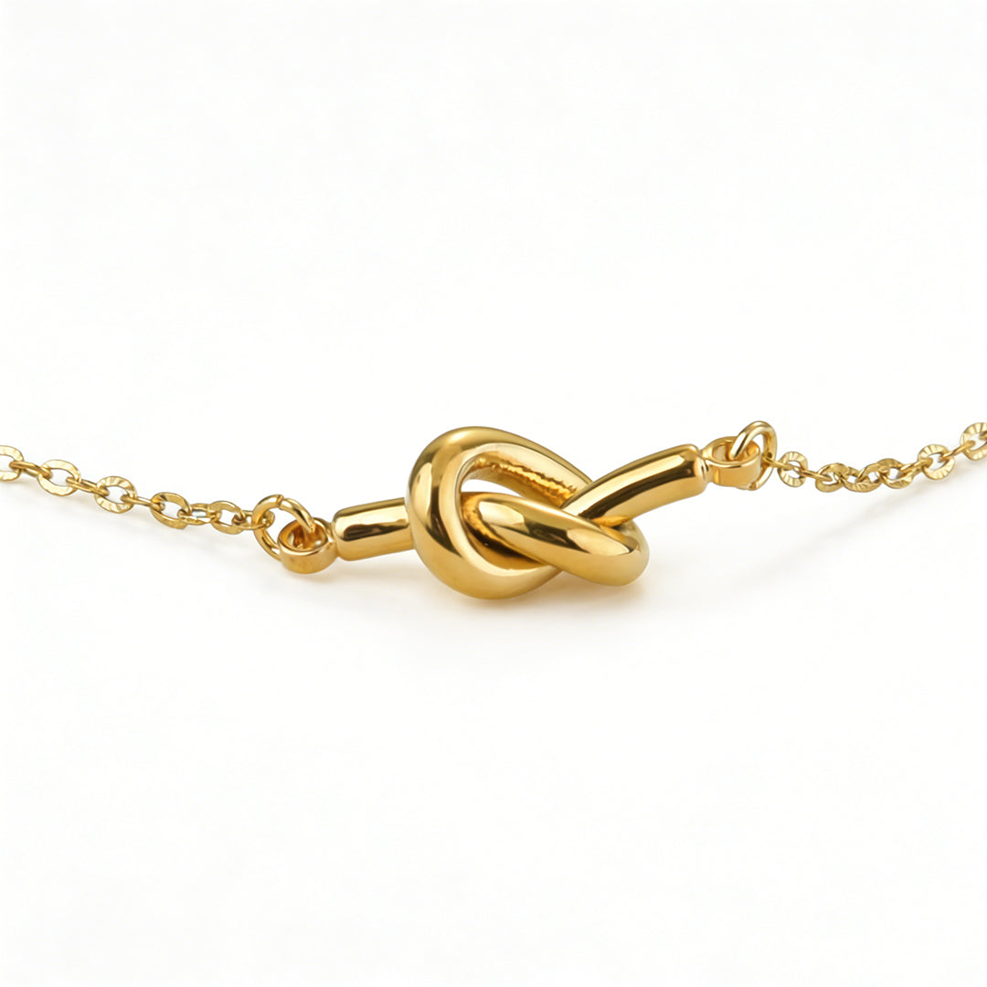 Abstract style gold pendant necklace with a reflective, uneven surface.