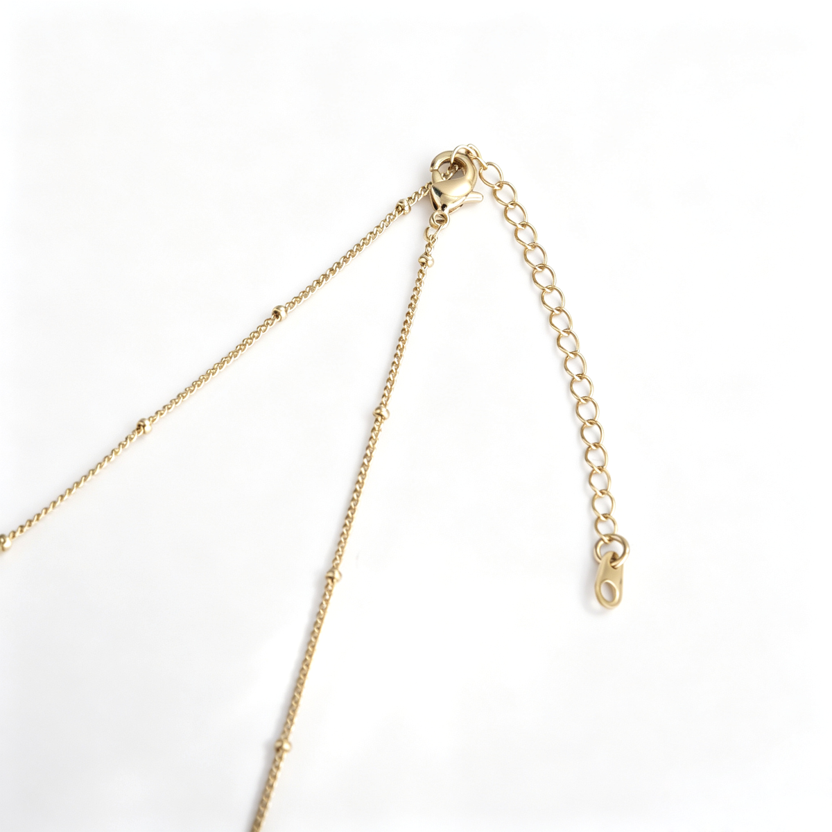 Lobster claw clasp and extension chain with teardrop charm on gold long necklace