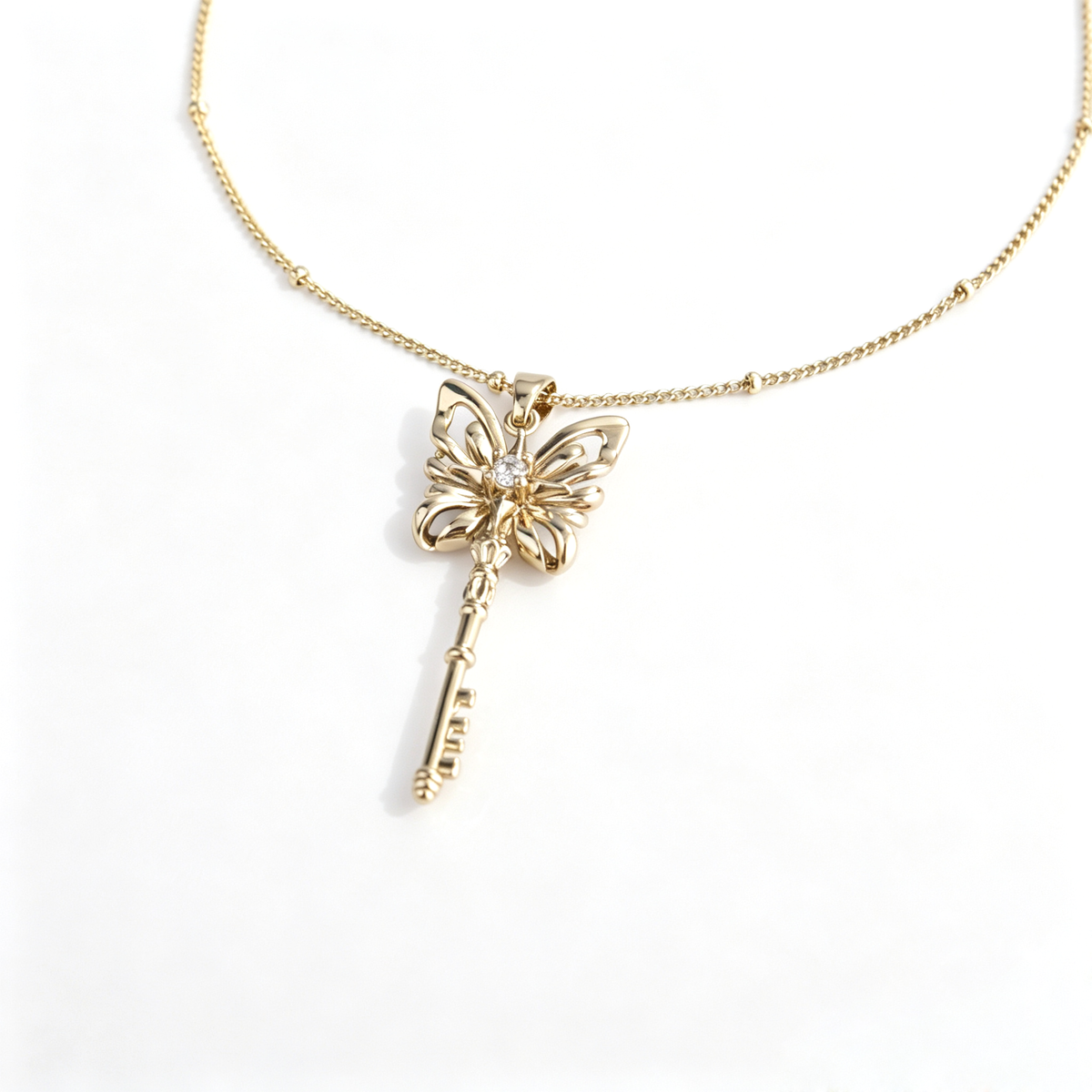 Close-up view of brass butterfly key pendant with sparkling center crystal