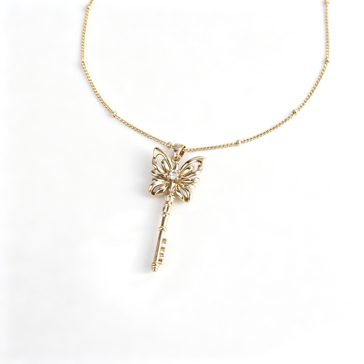 Detailed view of 1.9x3.5cm handcrafted brass butterfly key pendant and link chain