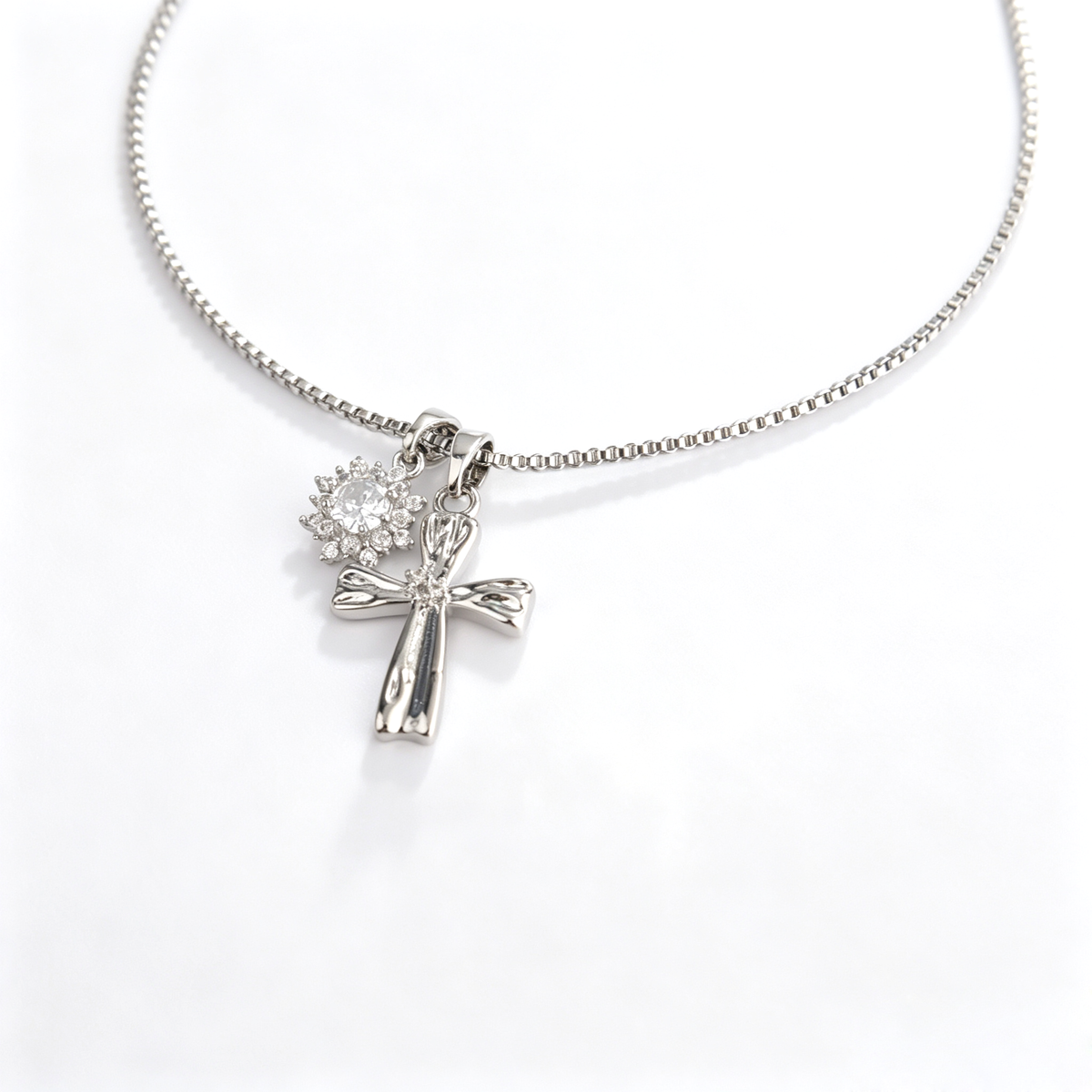 Front view of 1.2x2cm handcrafted silver cross and sparkling cz sunburst pendant
