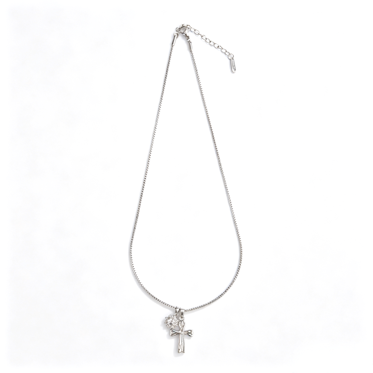 Angled close-up showing glossy silver cross and pavé crystal charm details