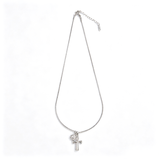 Angled close-up showing glossy silver cross and pavé crystal charm details