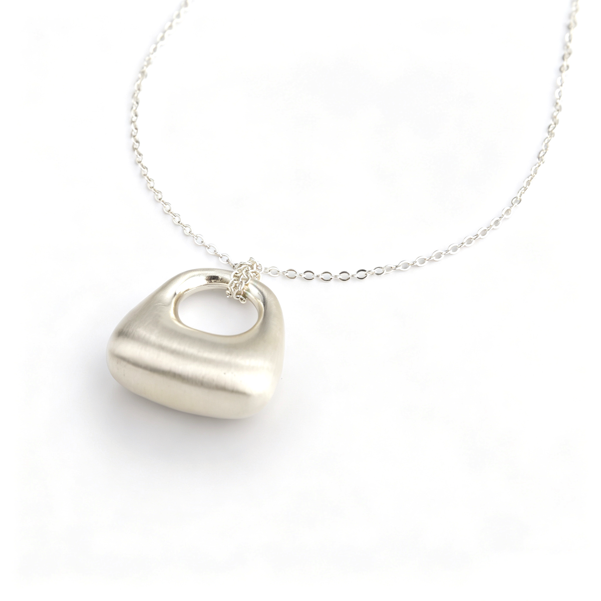 Close-up view of link chain loop attachment on handcrafted silver geometric pendant