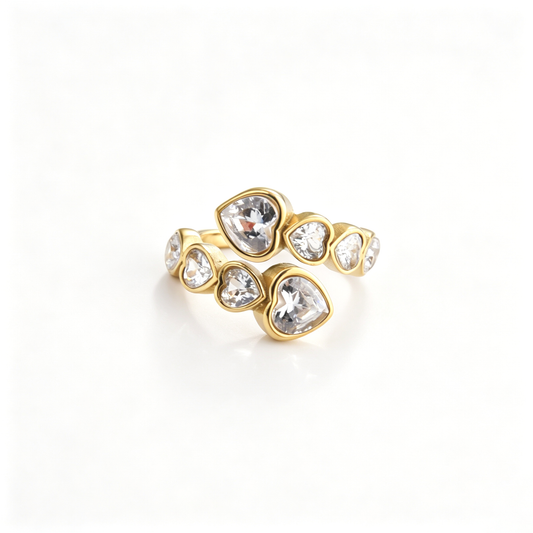 Open cuff ring viewed from the side, highlighting the curved band and heart-shaped accents