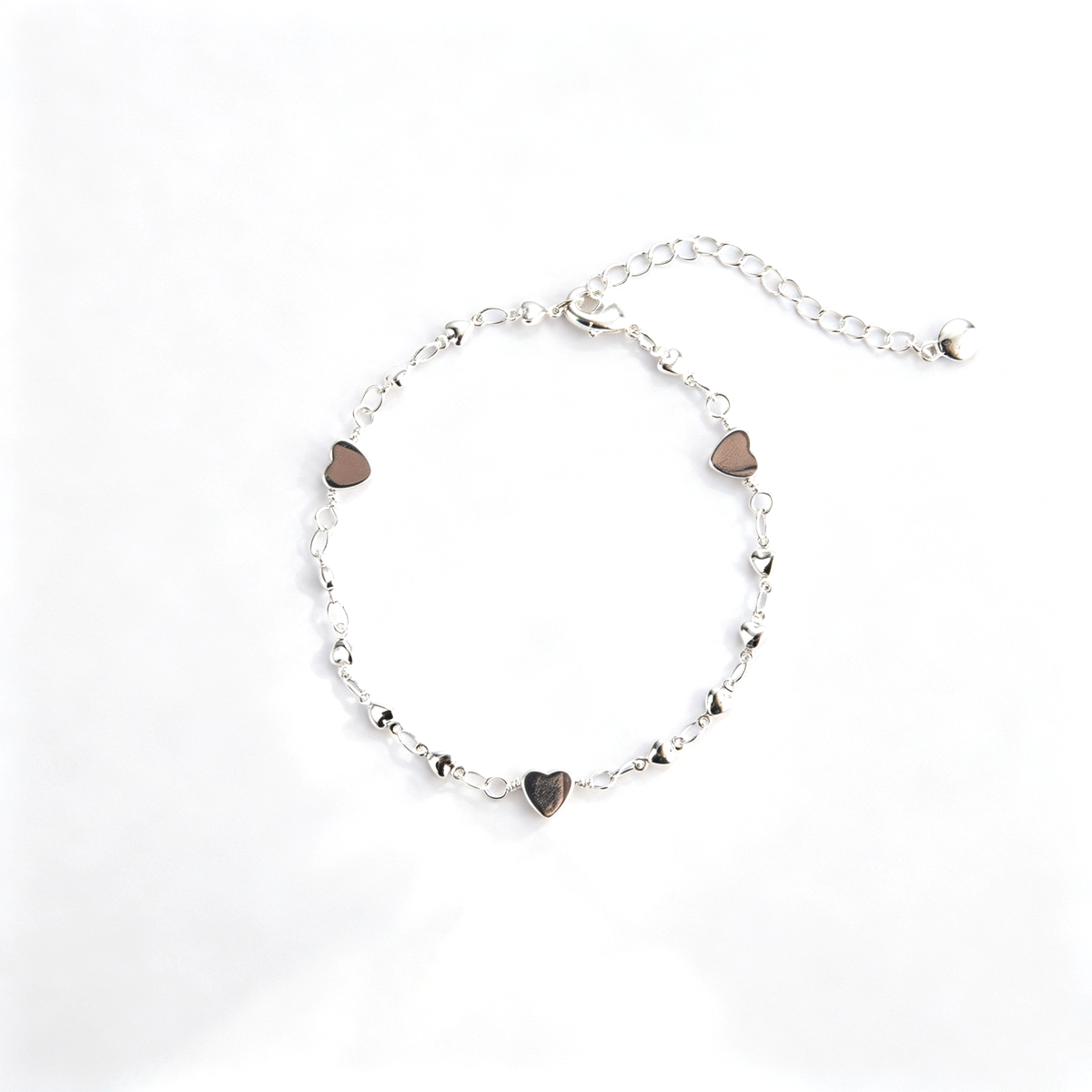 Heart charm bracelet with delicate chain links and multiple heart-shaped charms