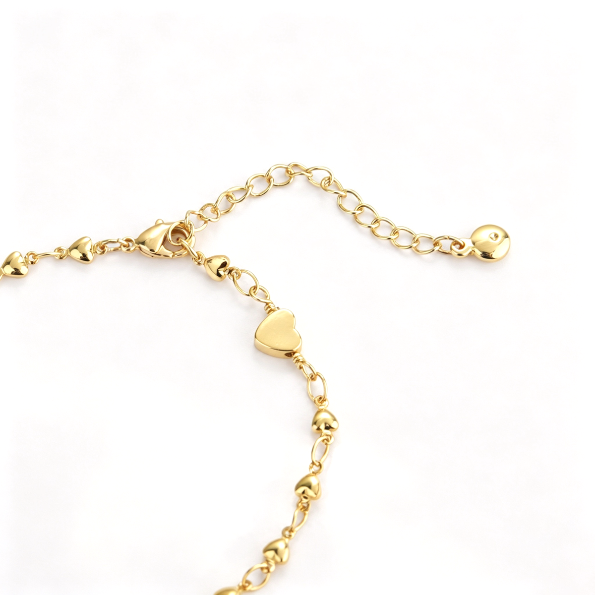 Close-up of the center heart charm and detailed chain links on the bracelet