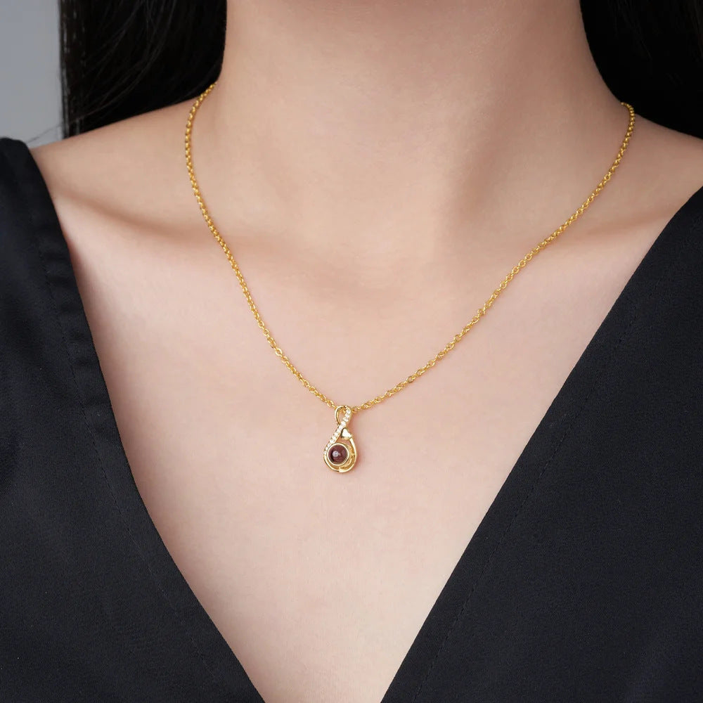 Necklace worn at the collarbone, showing the small pendant on a fine chain.