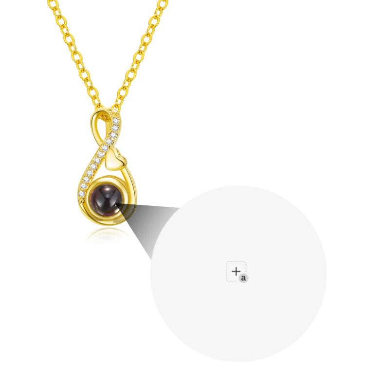 Gold-tone pendant close-up with a circular projection detail shown beside the design.