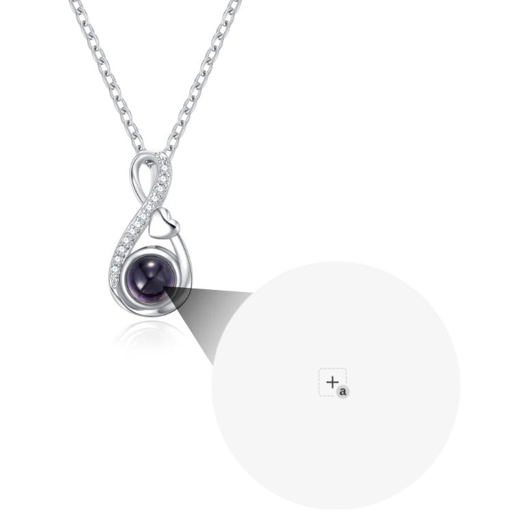 Silver-tone pendant close-up highlighting the rounded center and surrounding decorative outline.