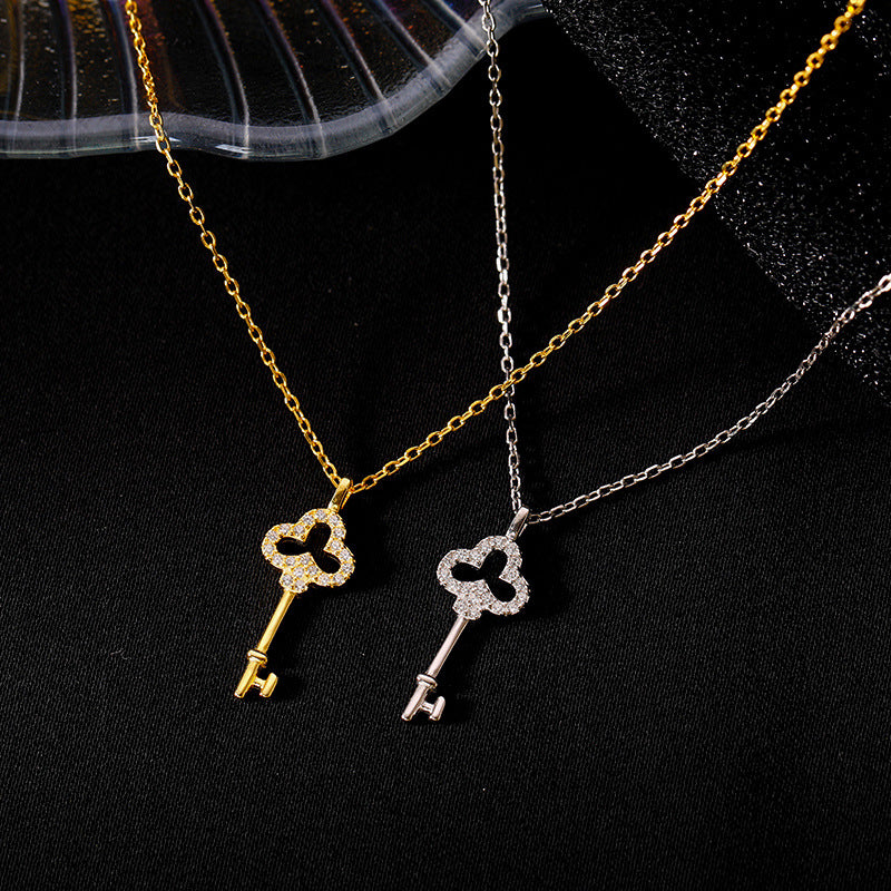 Gold-tone and silver-tone key pendant necklaces displayed side by side against black fabric