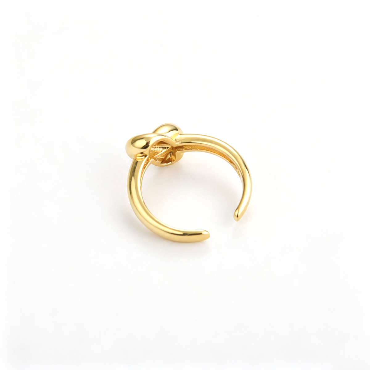 Knot cuff ring shown from a close angled view with its rounded sculptural centerpiece