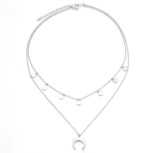Layered crescent moon necklace displayed flat, showing two chains, round dangling charms, and an open moon pendant.