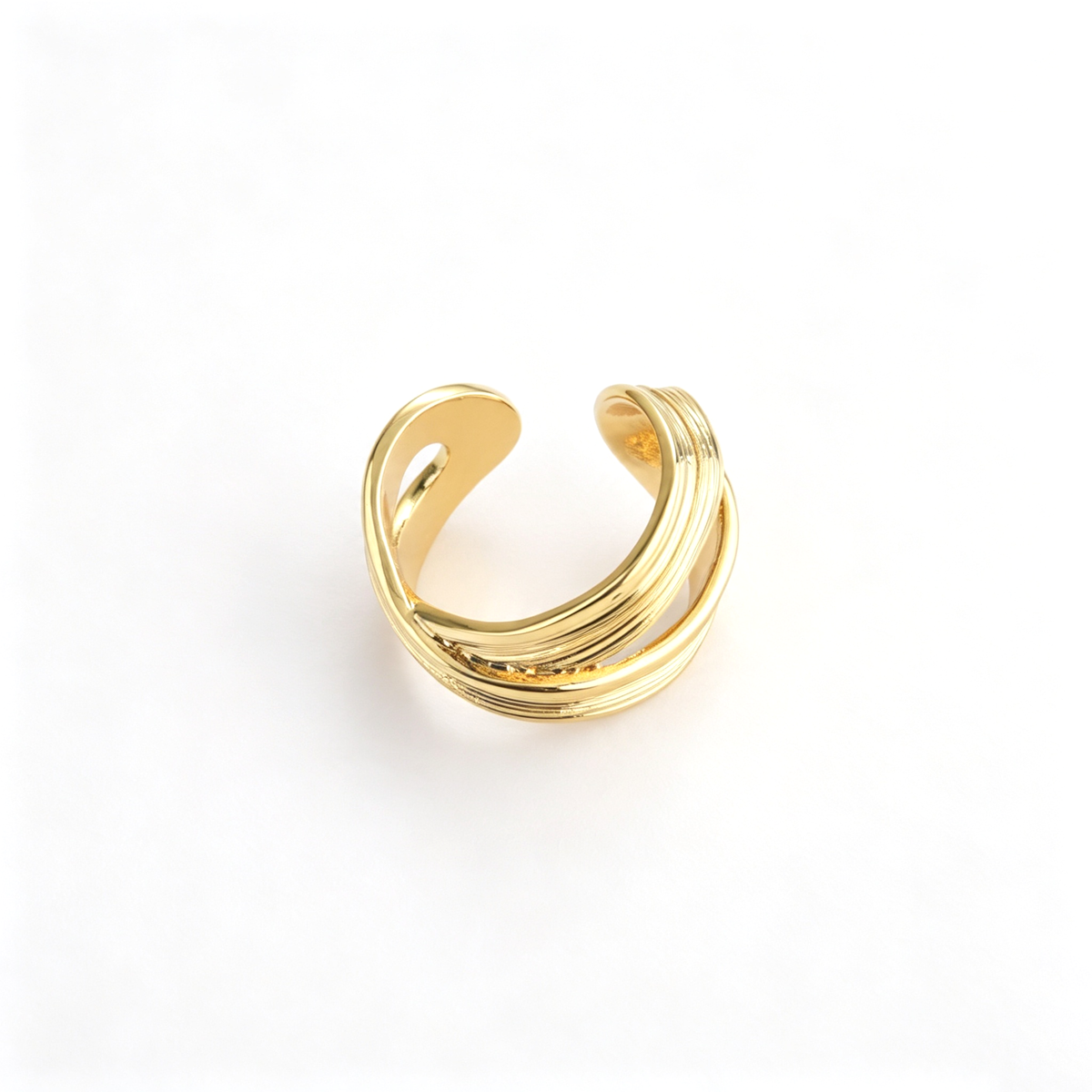 Layered wave cuff ring with flowing ribbed bands in a front angled view