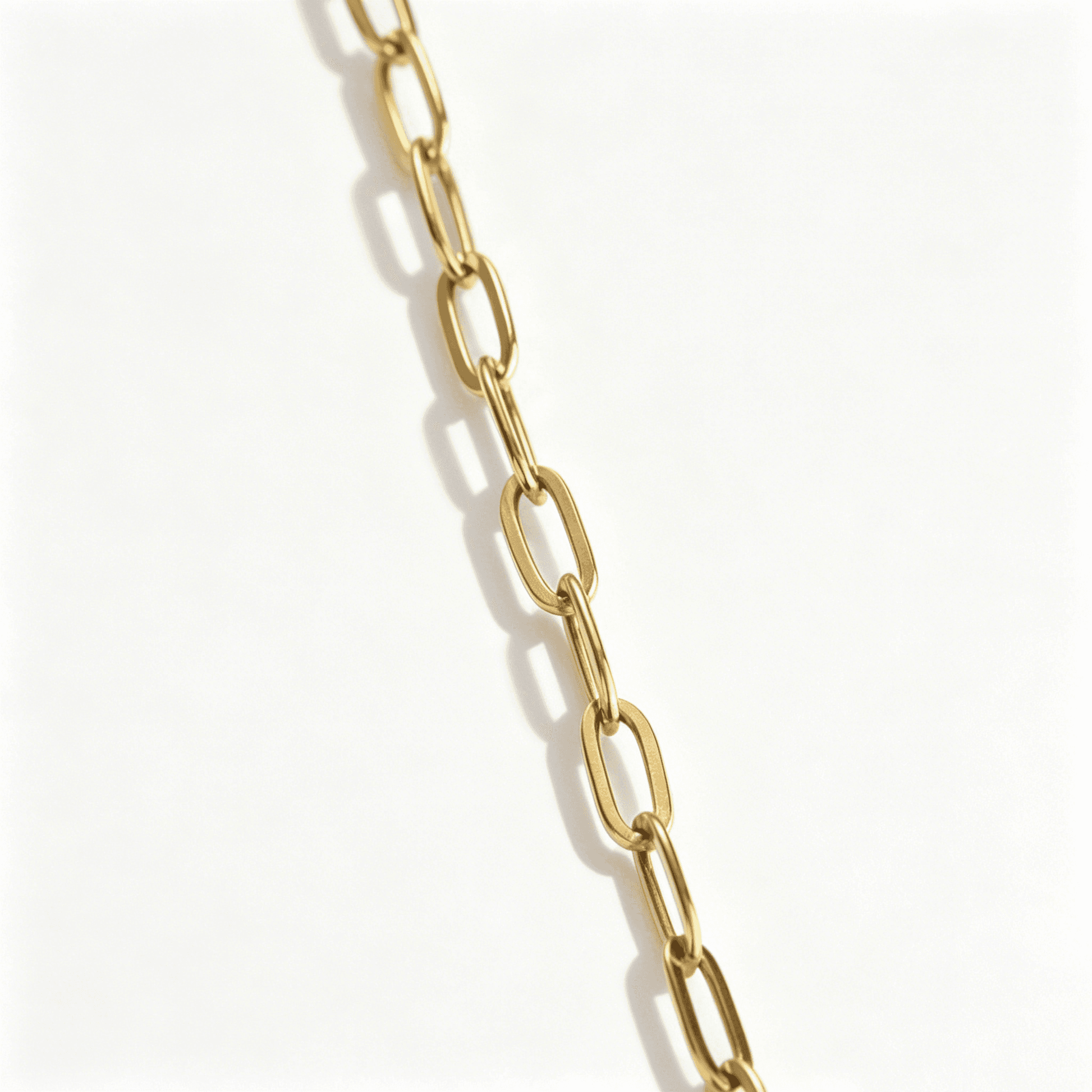 Detailed texture shot of the durable, gold plated paperclip chain link on matching necklaces for couples.