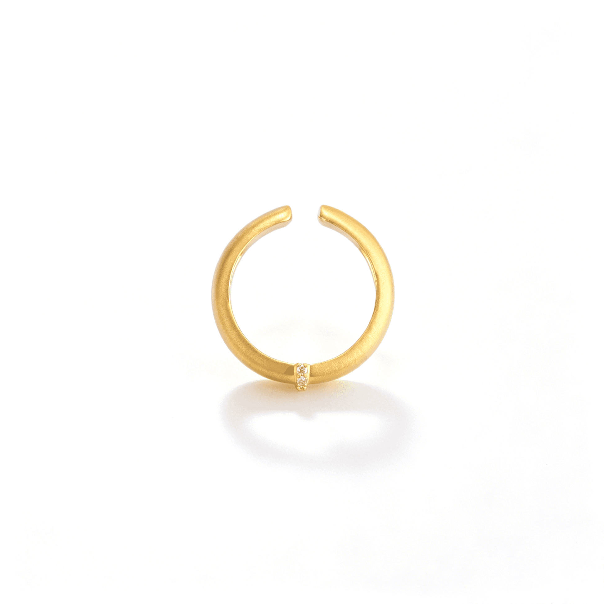 Top view of the gold-tone open ring highlighting its adjustable shape and centered zircon accent.