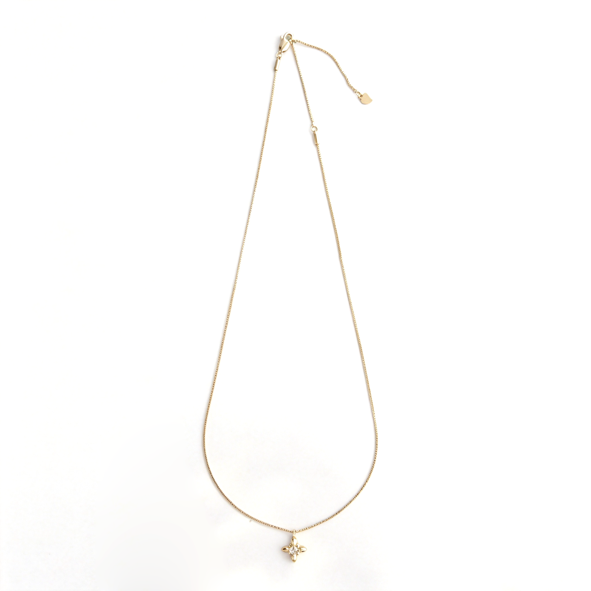 Full-length view of the gold box-chain necklace with adjustable ends and petite flower pendant.