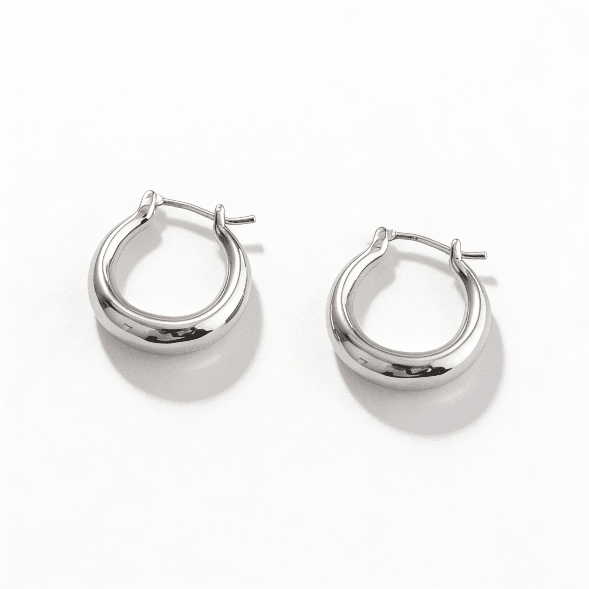 High-shine liquid silver statement earrings representing independent luxury and bold poise.