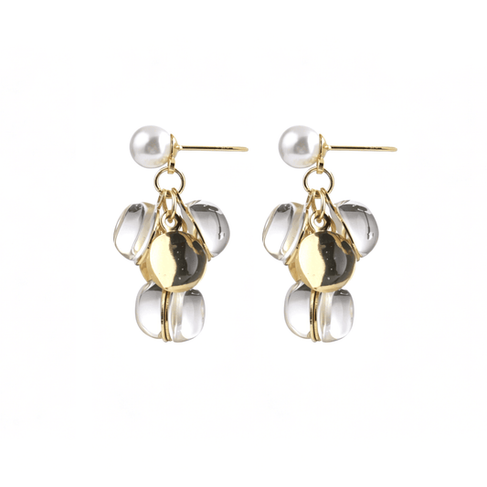 Centered front shot of the modern pearl stud drop earrings with spliced clear Lucite and reflective gold disc dangles.
