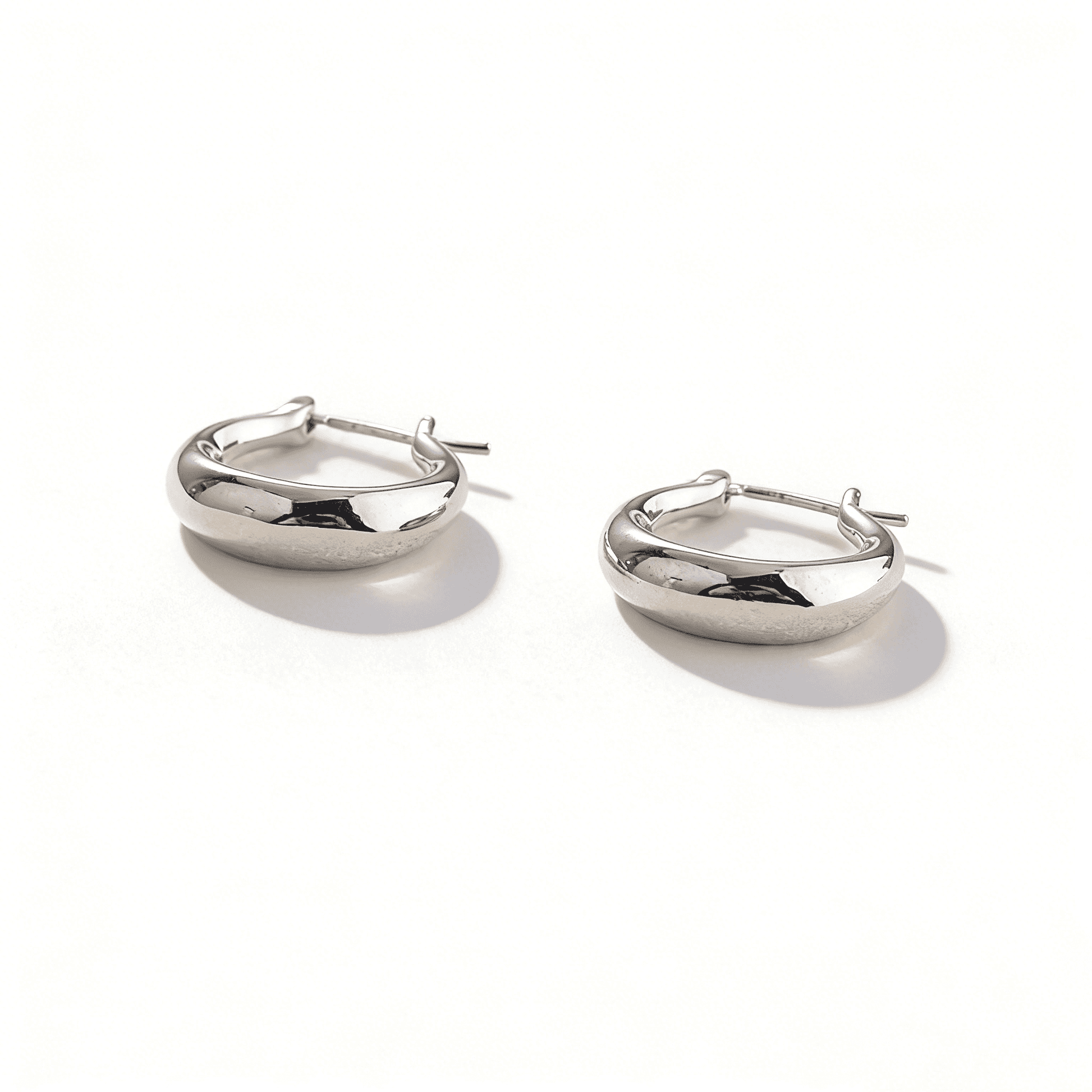 Detailed side profile of molten-textured silver hoops, showing the artistic irregular surface.