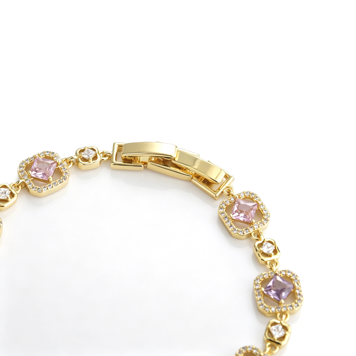 Close-up view of a secure gold-tone fold-over clasp on a multicolor cubic zirconia link bracelet.