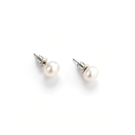 Pair of natural freshwater pearl stud earrings with silver posts laid flat on a white surface.