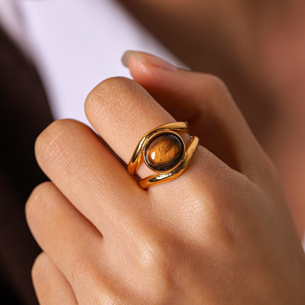 A close-up hand view highlighting the oval centerpiece ring and its curved band.