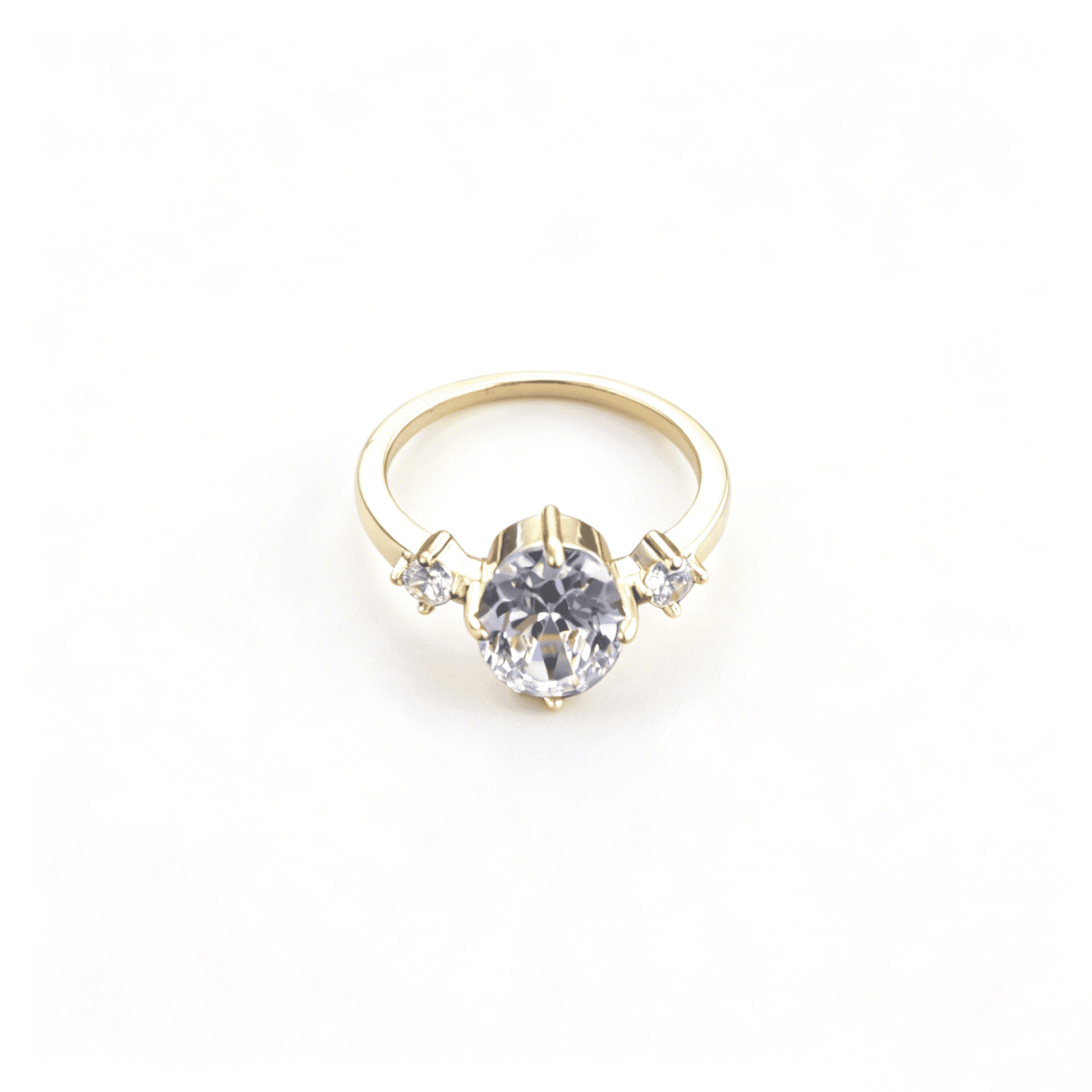 Front studio profile of the gold-plated three-stone heirloom ring showcasing a brilliant oval-cut cubic zirconia stone.