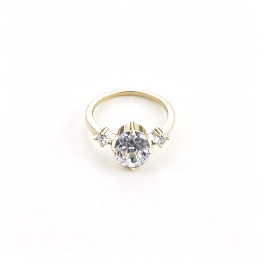 Front studio profile of the gold-plated three-stone heirloom ring showcasing a brilliant oval-cut cubic zirconia stone.
